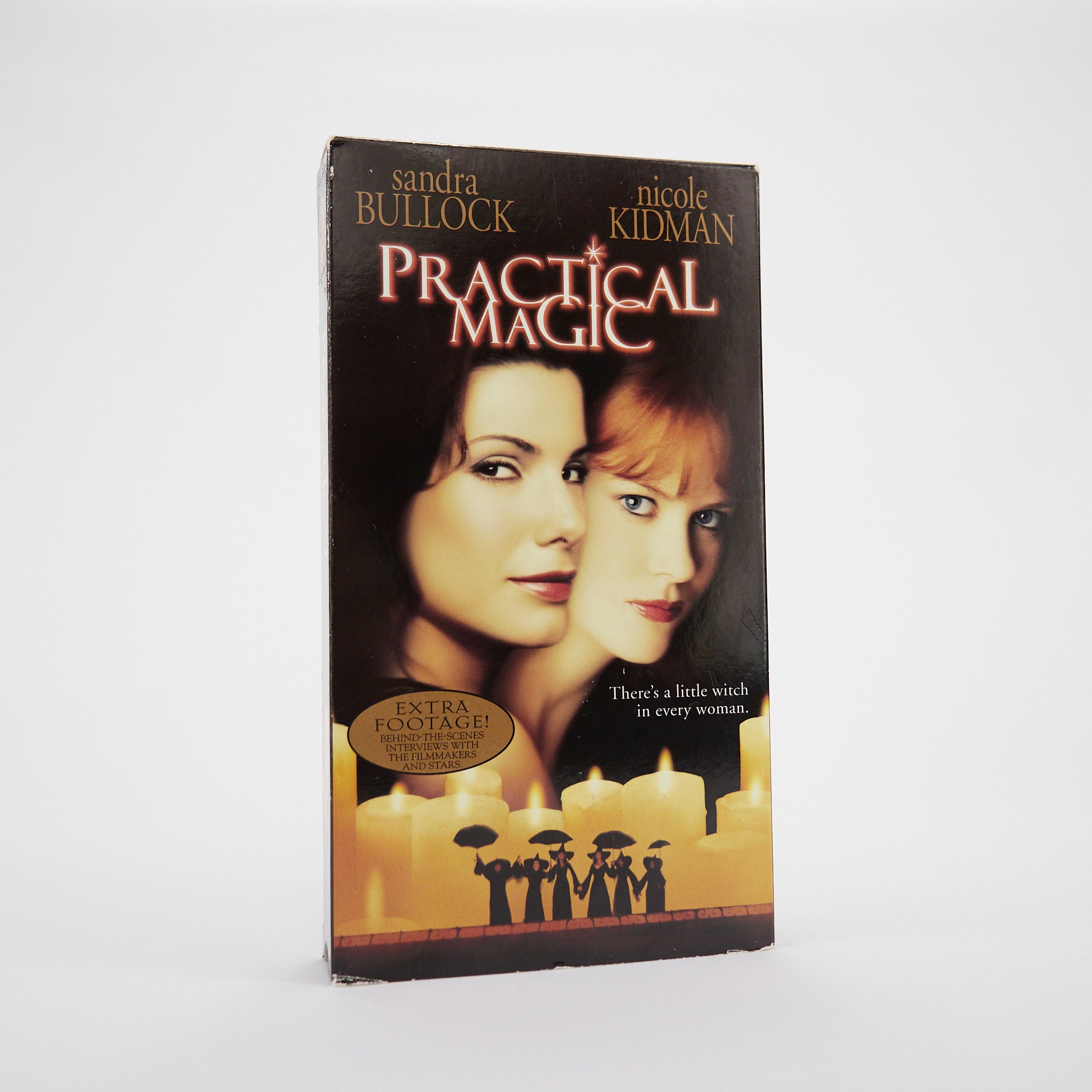 VHS cover of 'Practical Magic' with two women's faces and candles on a white background